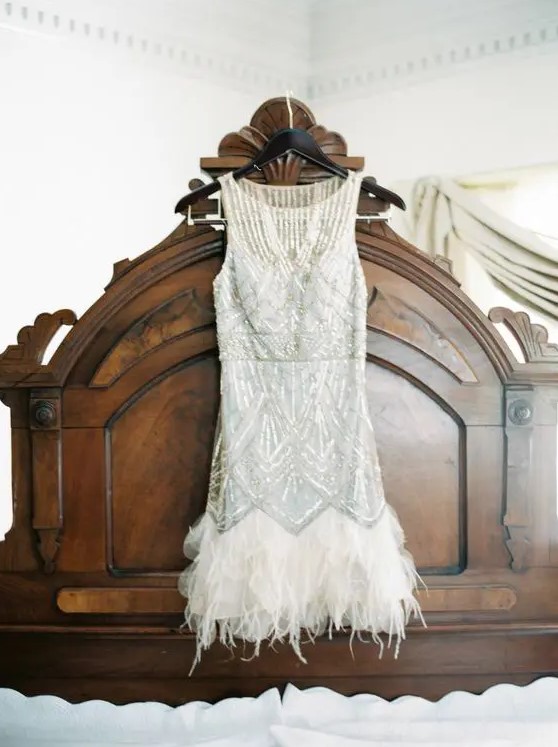 a short sleeveless wedding dress with silver beading and a feather edge on the skirt is a perfect solution for a 1920s wedding
