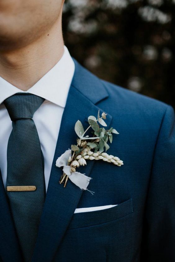 a simple and dimensional wedding boutonniere of eucalyptus and white dried bloom bulbs plus a white ribbon piece is a cool and fresh idea