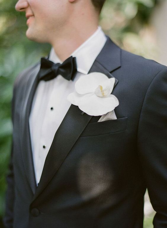 a single white orchid boutonniere is a fresh and eye0catchy touch to the groom's look and is always on trend