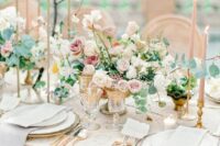 a sophisticated wedding table setting with neutral and blush blooms, a blush tablecloth and neutral napkins