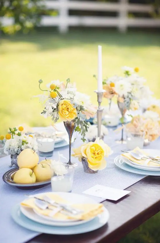a sophisticated wedding tablescape with a printed runner, yellow blooms, candles and napkins and candles is chic