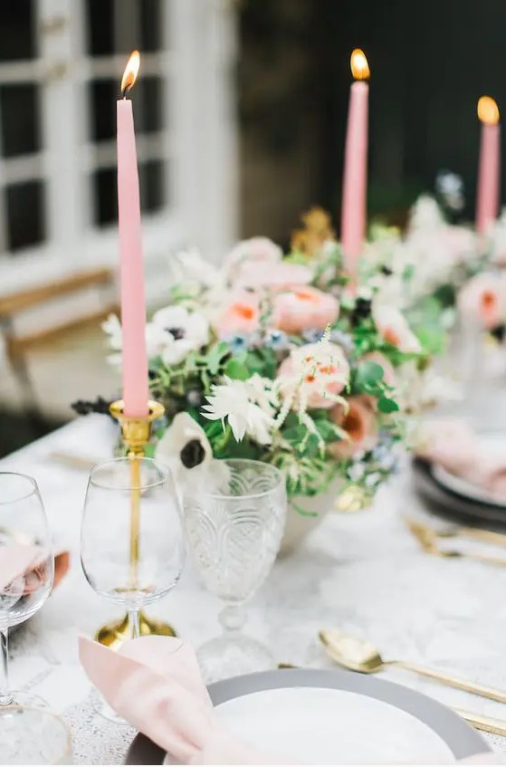 a spring garden wedding tablescape with pink candles and napkins, with pink and white blooms and greenery