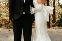 a strapless plain mermaid wedding dress with a large bow on the back and long gloves are an amazing combo for a wedding