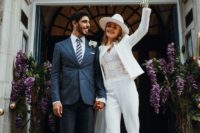 a stylish white pantsuit, a white lace bodysuit, white heels and a white fedora for a modern bride