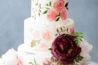 a sweet pastel handpainted wedding cake in various subtle shades with fresh blooms on top is ideal for summer