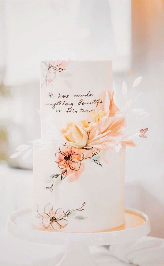 a tender and delicate wedding cake with hand painted pastel blooms and leaves, with some quotes and fresh pastel blooms is amazing for spring