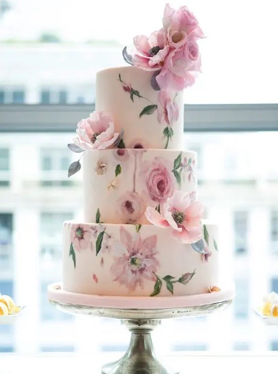 a tender pastel handpainted floral wedding cake done in pinks and greens and decorated with natural blooms
