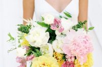 a unique wedding bouquet of pink tulips and peonies, yellow and white blooms and greenery is a gorgeous watercolor-style idea