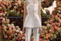 a whimsy white pantsuit with fitting pants, a strapless bow top and neutral shoes