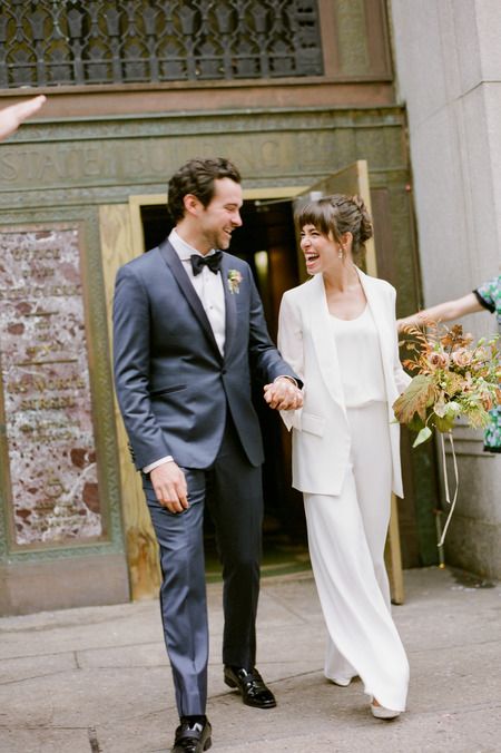 a white minimalist pantsuit with palazzo pants, an oversized blazer, a white top and platform heels for a minimal bride