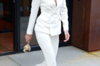 a white pantsuit with a long double-breasted blazer, copper shoes and layered necklaces for a modern look