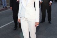 a white pantsuit with a plunging neckline, a neutral deep cut top and metallic shoes for a glam modern bride