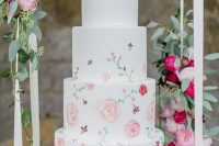 a white wedding cake decorated with primitive style hand painted pink and red blooms and leaves is a great idea for summer