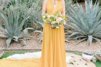 a yellow A-line wedding dress with no sleeves, a draped bodice and a pleated skirt with a train is a gorgeous idea for a boho or modern bride