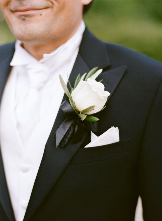 an elegant modern white rose and greeneyr boutonniere with a black bow tie is a stylish idea to spruce up a classic tux and make it cooler