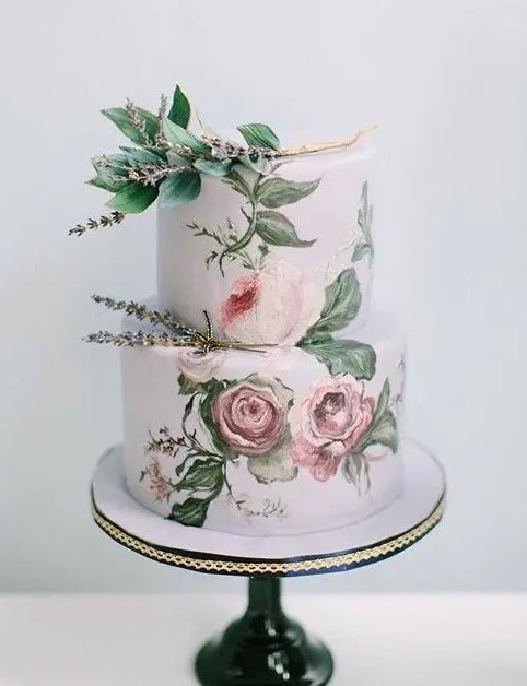 an exquisite handpainted wedding cake with rose and some lavender on top looks like a real work of art