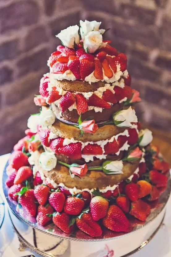 a jaw dropping naked wedding cake with whipped cream, garden roses and lots of strawberries is a fantastic idea for a summer wedding