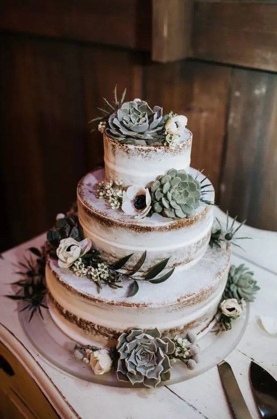 a lovely naked wedding cake decorated with succulents, thistles and white blooms is a beautiful idea for a spring or summer wedding
