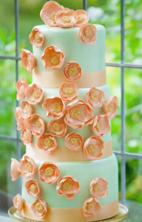 a whimsical mint wedding cake with orange sugar blooms and orange ribbons is a lovely idea for a bright summer wedding