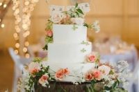 104 a white buttercream wedding cake decorated with neutral and peachy blooms, greenery, a banner cake topper is a lovely idea for a summer wedding