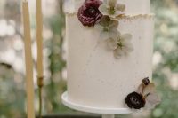 116 a white textural wedding cake with a gold glitter edge, fresh blooms is an elegant and romantic piece for a summer or fall wedding