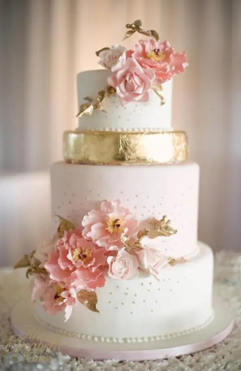 an elegant wedding cake with white, blush and gold leaf tiers, with blush and coral sugar blooms and gold leaves for an elegant summer wedding