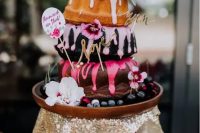 132 a creative three-tier bundt wedding cake with colorful drip, greenery and bold blooms and funny toppers