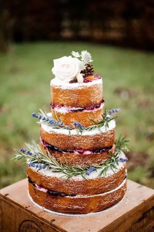 a naked wedding cake with lavender, blooms, pinecones and macarons is a trendy and yummy rustic wedding cake