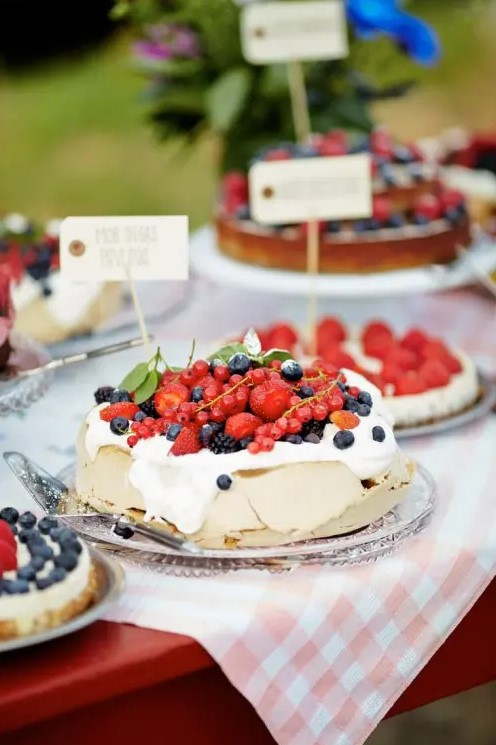 a pavlova wedding cake topped with cream and fresh berries is a great alternative to a usual wedding cake, it looks yummy and cool