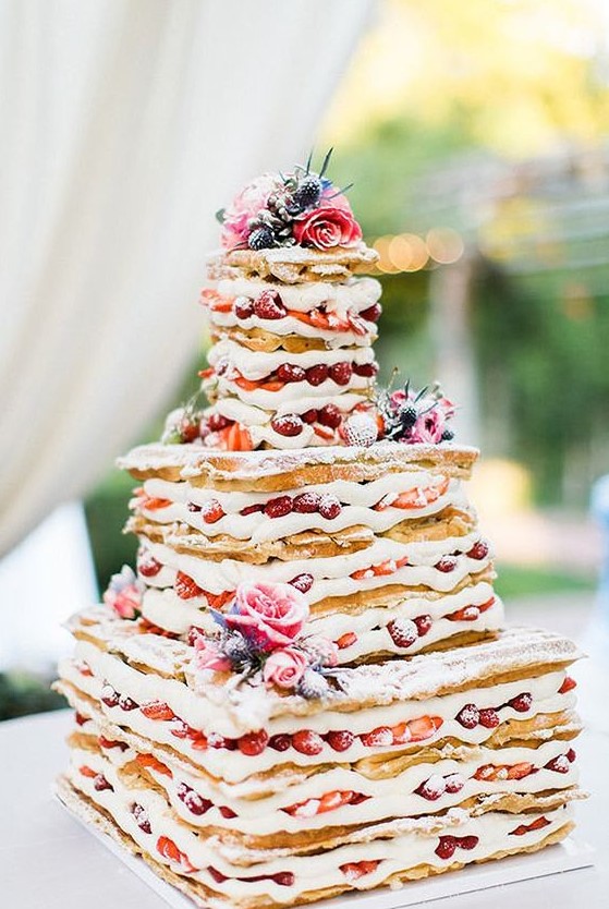 a waffle wedding cake with creamy filling, lots of berries and fresh blooms for a rustic brunch wedding in summer