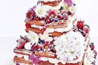 148 an oversized waffle wedding cake with various types of berries, white and pink blooms and some meringues