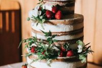 15 a naked wedding cake with fresh strawberries, greenery and white blooms plus a topper for a summer rustic wedding