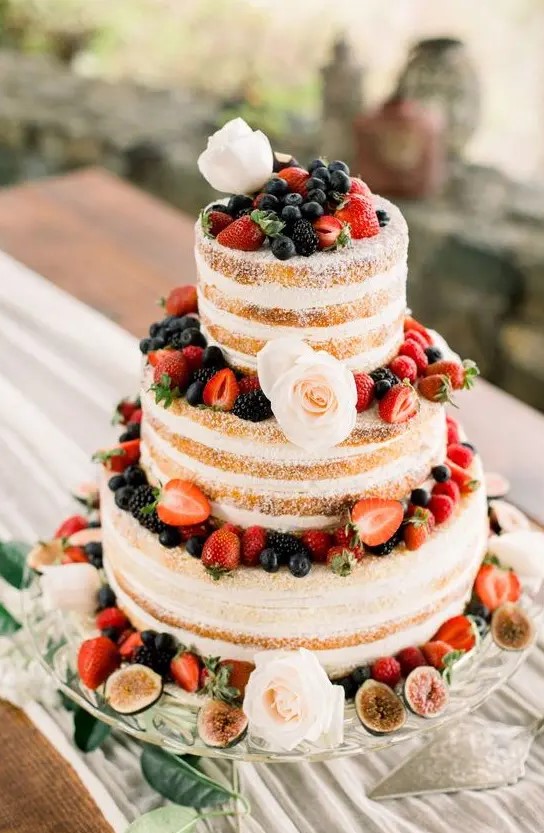 a naked wedding cake with fresh berries and blush blooms is a nice option for a summer rustic wedding