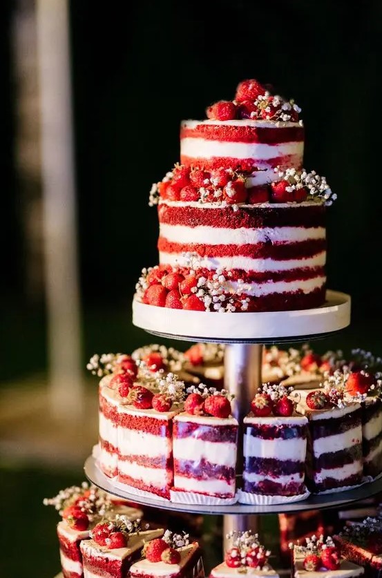 a red velvet wedding cake with white baby's breath and fresh berries is a gorgeous idea for a rustic wedding