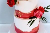 32 a beautiful and chic wedding cake done with red and gold leaf textural touches, pink and red roses and greeenery, gilded cherries on top