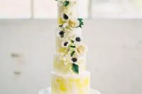 47 a bright spring five tier wedding cake with bold yellow touches, neutral blooms and leaves is a real masterpiece