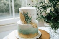 59 a fantastic wedding cake with a white and an ombre green tier, gold brushstrokes and leaves and green marble-like pieces