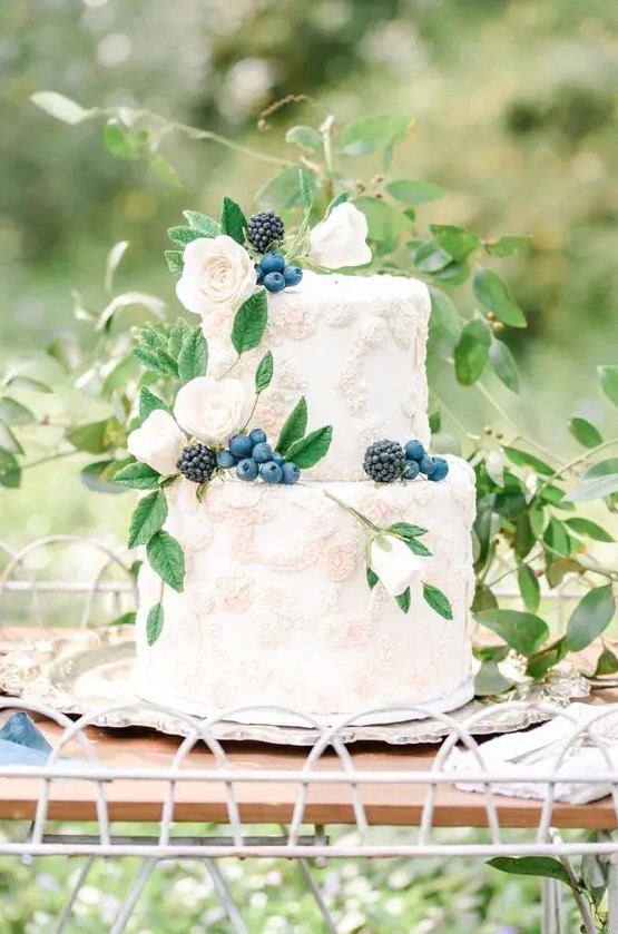 a heavenly secret garden wedding cake with sugar floral detailing, fresh berries and some foliage is a delicate and refined idea