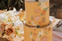 65 a honey yellow wedding cake with a rough edge, painted dimensional blooms and beads plus a cactus topper for a boho flower child wedding