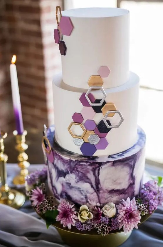 a jaw dropping round wedding cake with a purple watercolor and white tiers, with 3D hexagons covering the tiers is just fantastic
