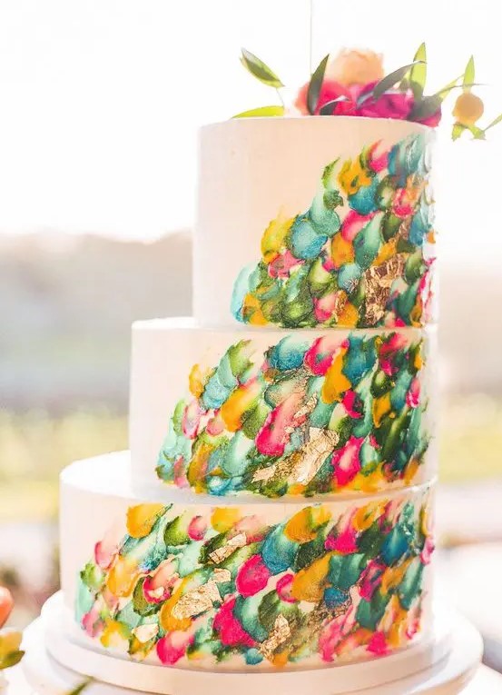 a jaw dropping wedding cake with colorful brushstrokes and bold blooms on top is a very cool idea