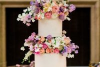 72 a modern white wedding cake with super bright and blush blooms between the tiers looks wow