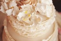 73 a neutral buttercream wedding cake with ruffles and sugar blooms on top is a gorgeous idea for a spring or summer wedding