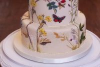 75 a painted wedding cake with flowers, laves, branches and butterflies is a lovely and bold idea to go for, looks amazing