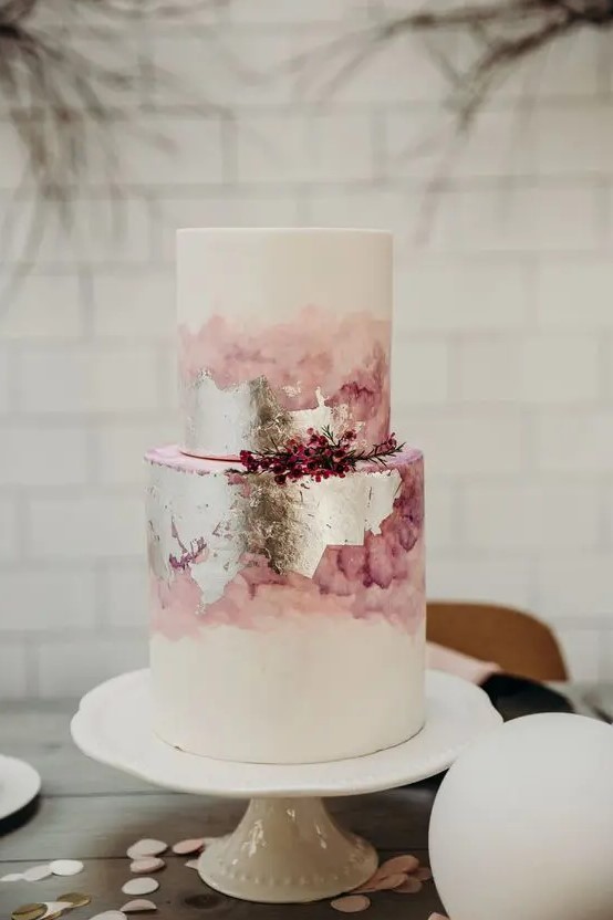 a pink watercolor and silver leaf wedding cake with pink berries is a very eye-catchy and chic idea for a modern wedding
