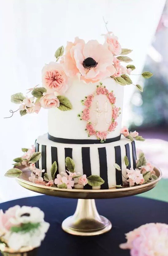a pretty spring or summer wedding cake with a black and white vertical stripe tier and a white one with floral decor, with pink sugar and fresh blooms