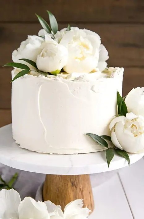 a small textural white wedding cake topped with white peonies for a chic look is a great idea for an all white wedding