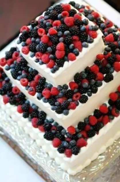 a square white buttercream wedding cake fully topped with fresh berries is a lovely idea for a summer wedding, berries always scream summer