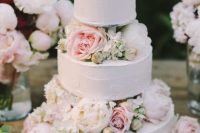 92 a subtle white textural wedding cake with white and blush blooms is very tender and cute