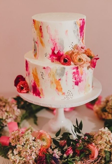 a super bright two-tier wedding cake with bold watercolors, speckles and bright blooms is a great idea for a summer wedding